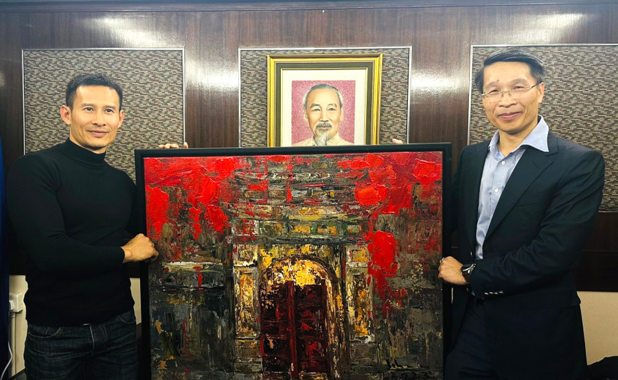 Ông Phạm Bình Đàm (bên phải), Tổng Lãnh sự Việt Nam tại Hong Kong (Trung Quốc) nhận bức tranh do dự án Mỹ thuật Việt Nam và Ngoại giao Văn hóa tặng
