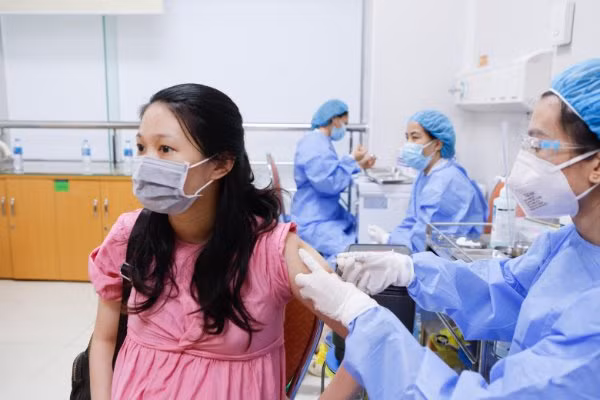 Bà bầu được tư vấn, giải đáp các thắc mắc, giúp tâm lý thoải mái trước khi tiêm vắc xin.