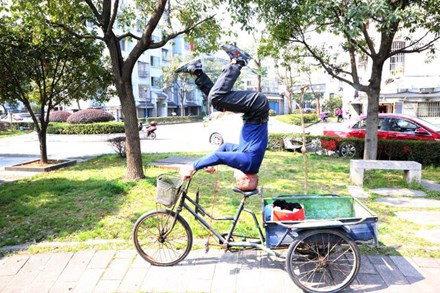 Người đàn ông "trồng cây chuối" điều khiển xe ba bánh 