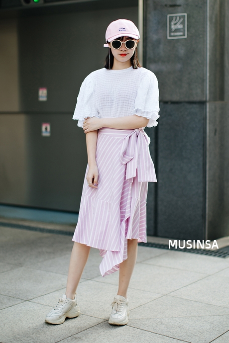 Áo phông với một chút nhấn nhá bèo tay cùng họa tiết caro hồng của cô bạn này đã khiến item mùa hè đa dạng hơn. Cách phối với chân váy hồng sọc trắng lại càng thể hiện tư duy thời trang của cô nàng rất hoàn hảo. Thậm chí những item đi kèm cũng bổ trợ đắc lực cho tổng thể set đồ. 