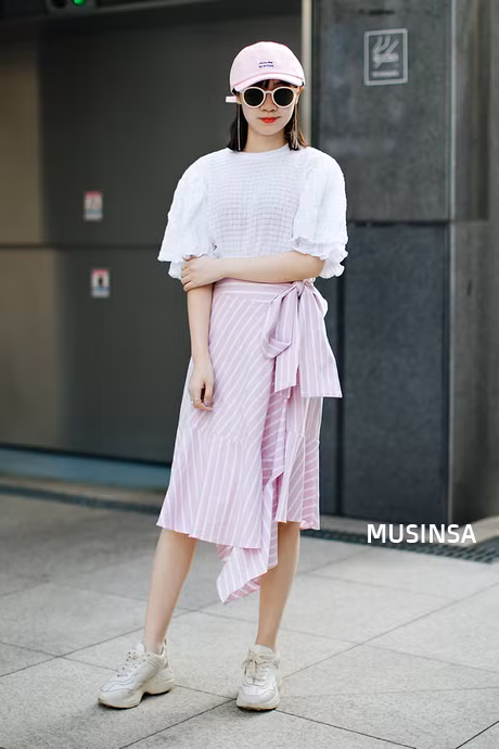 Áo phông với một chút nhấn nhá bèo tay cùng họa tiết caro hồng của cô bạn này đã khiến item mùa hè đa dạng hơn. Cách phối với chân váy hồng sọc trắng lại càng thể hiện tư duy thời trang của cô nàng rất hoàn hảo. Thậm chí những item đi kèm cũng bổ trợ đắc lực cho tổng thể set đồ. 