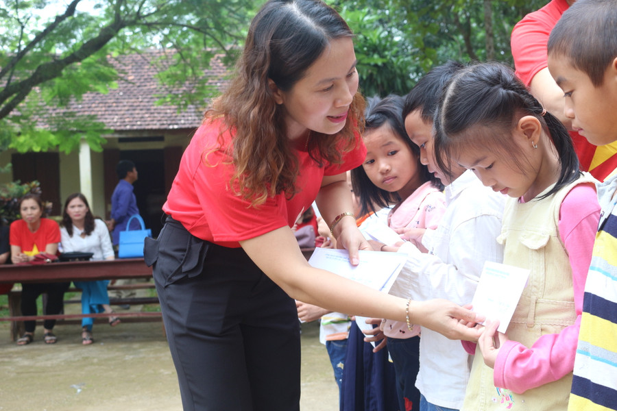 Cô giáo Dương Thị Thu Hà, Hiệu trưởng Trường tiểu học Hoàng Hoa Thám trao quà cho những học sinh có hoàn cảnh khó khăn
