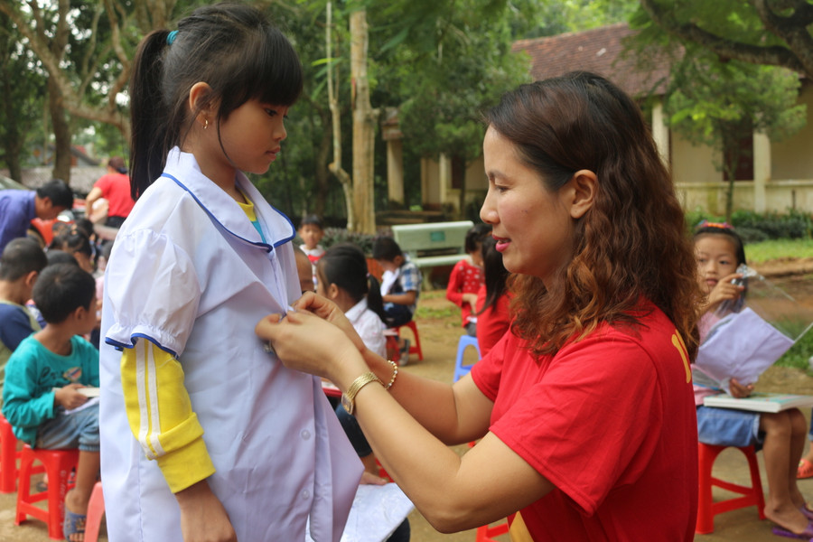 Cô giáo Dương Thị Thu Hà, Hiệu trưởng Trường tiểu học Hoàng Hoa Thám tặng áo đồng phục cho học sinh vùng lũ