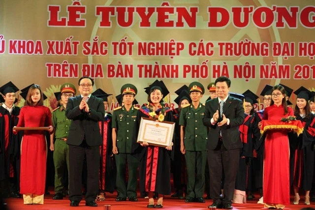 Ông Hoàng Trung Hải, Ủy viên Bộ Chính trị, Bí thư Thành ủy Hà Nội(trái) và Thứ trưởng Bộ GD&ĐT Nguyễn Hữu Độ trao bằng khen và hoa vinh danh thủ khoa.