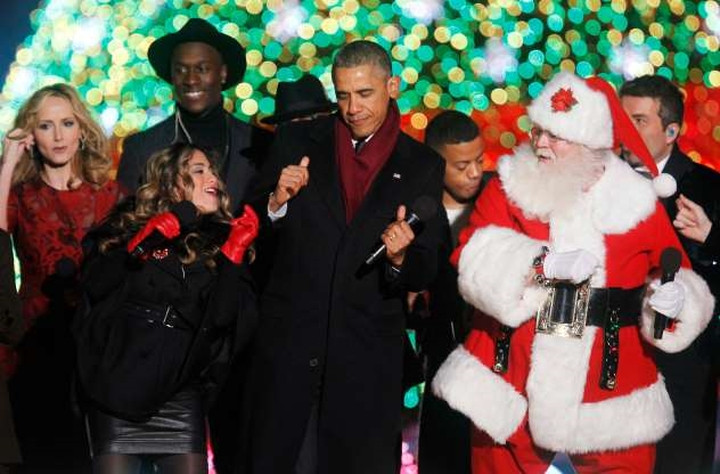 Tổng thống Obama đang nhún nhảy theo nhạc bên cạnh ông già Noel trong lễ thắp sáng cây thông năm 2014. Tổng thống Obama đang nhún nhảy theo nhạc bên cạnh ông già Noel trong lễ thắp sáng cây thông năm 2014.