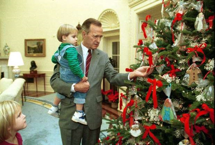 Giáng sinh đầu tiên của Tổng thống George H.W. Bush (cha) ở Nhà Trắng lại là sự kiện mang tính gia đình. Trong ảnh là Tổng thống Bush cha cùng cháu mình bên cây thông Noel ở Phòng Bầu dục. Giáng sinh đầu tiên của Tổng thống George H.W. Bush (cha) ở Nhà Trắng lại là sự kiện mang tính gia đình. Trong ảnh là Tổng thống Bush cha cùng cháu mình bên cây thông Noel ở Phòng Bầu dục.