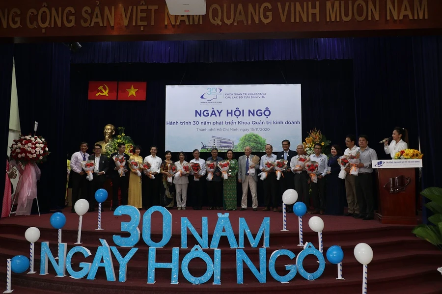 Đại diện Ban giám hiệu tặng hoa chúc mừng các cựu sinh viên của trường trong dịp trở về.