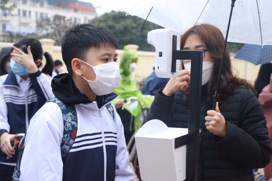Học sinh đo thân nhiệt, sát khuẩn tay bằng thiết bị tự động đặt ở cổng trường.