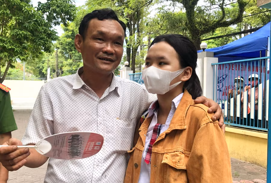 Phụ huynh hỏi thăm về kết quả làm bài của con sau khi hết giờ làm bài thi môn Ngữ văn.