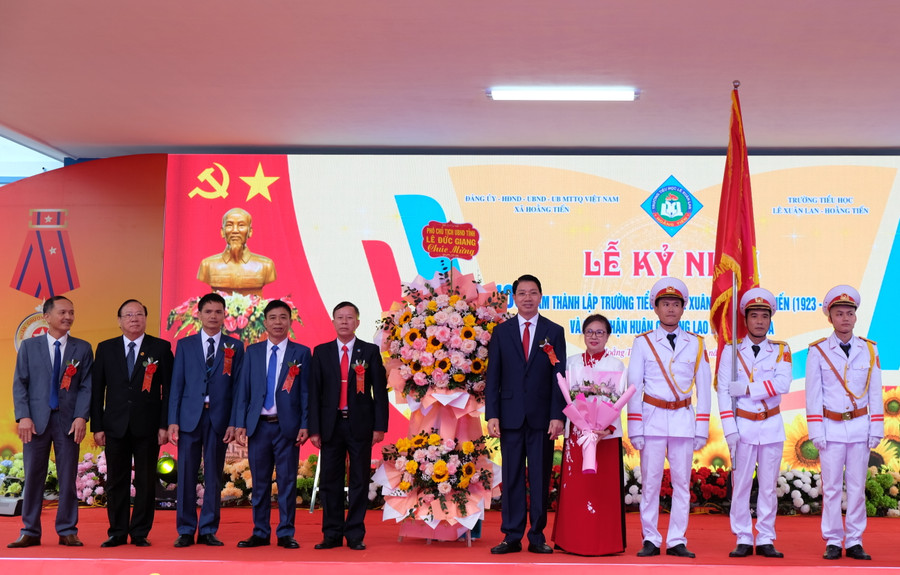 Ông Lê Đức Giang, Phó Chủ tịch UBND tỉnh Thanh Hoá tặng hoa chúc mừng Nhà trường và gia đình hậu duệ nhà giáo Lê Xuân Lan. (Ảnh: NT)