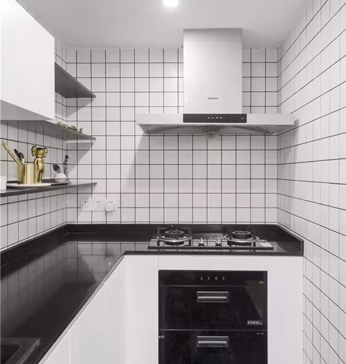 Khu bếp nhỏ dạng chữ L ốp gạch trắng đen nổi bật. Hệ thống khử mùi được gia chủ đặc biệt chú ý để không ám mùi nấu nướng ra cả không gian phòng khách. Khu bếp nhỏ dạng chữ L ốp gạch subway trắng miết mạch đen nổi bật.