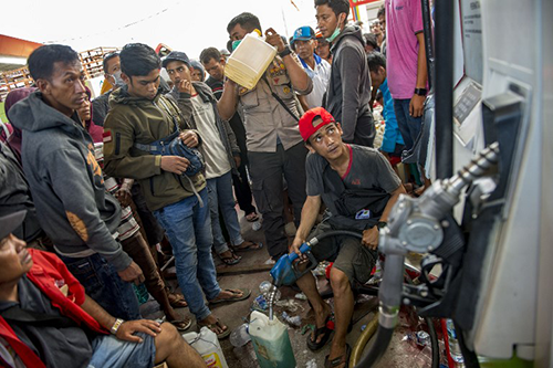 Người dân xếp hàng chờ lấy xăng ở một trạm xăng tại Palu. Ảnh: AFP