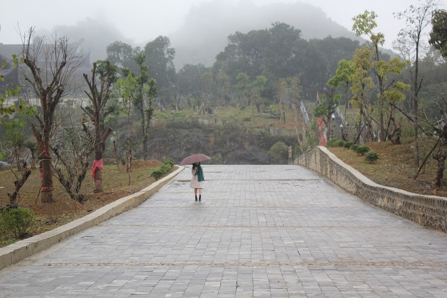 Du khách che ô, đeo khẩu trang tới chùa Tam Chúc. Ảnh: Trần Hồng Hạnh