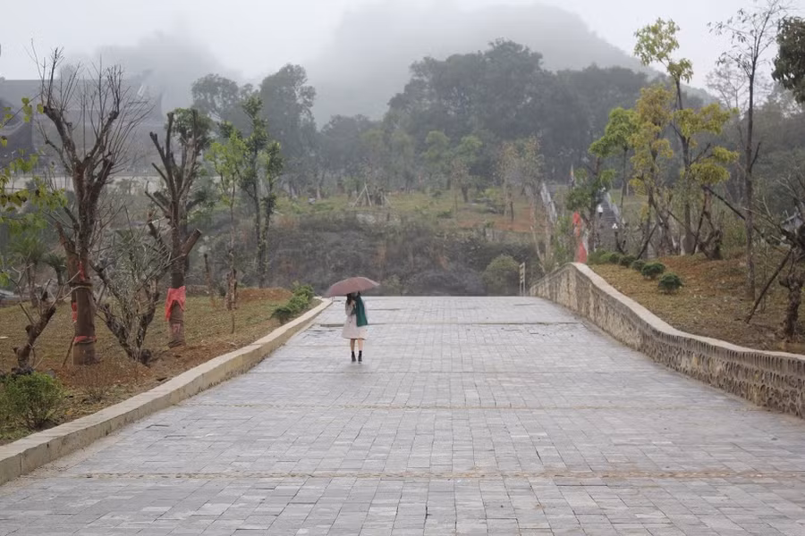 Du khách che ô, đeo khẩu trang tới chùa Tam Chúc. Ảnh: Trần Hồng Hạnh