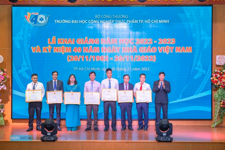 PGS.TS Nguyễn Xuân Hoàn (bìa phải), Hiệu trưởng HUFI trao bằng khen của Bộ cho các giảng viên có thành tích xuất sắc trong công tác.