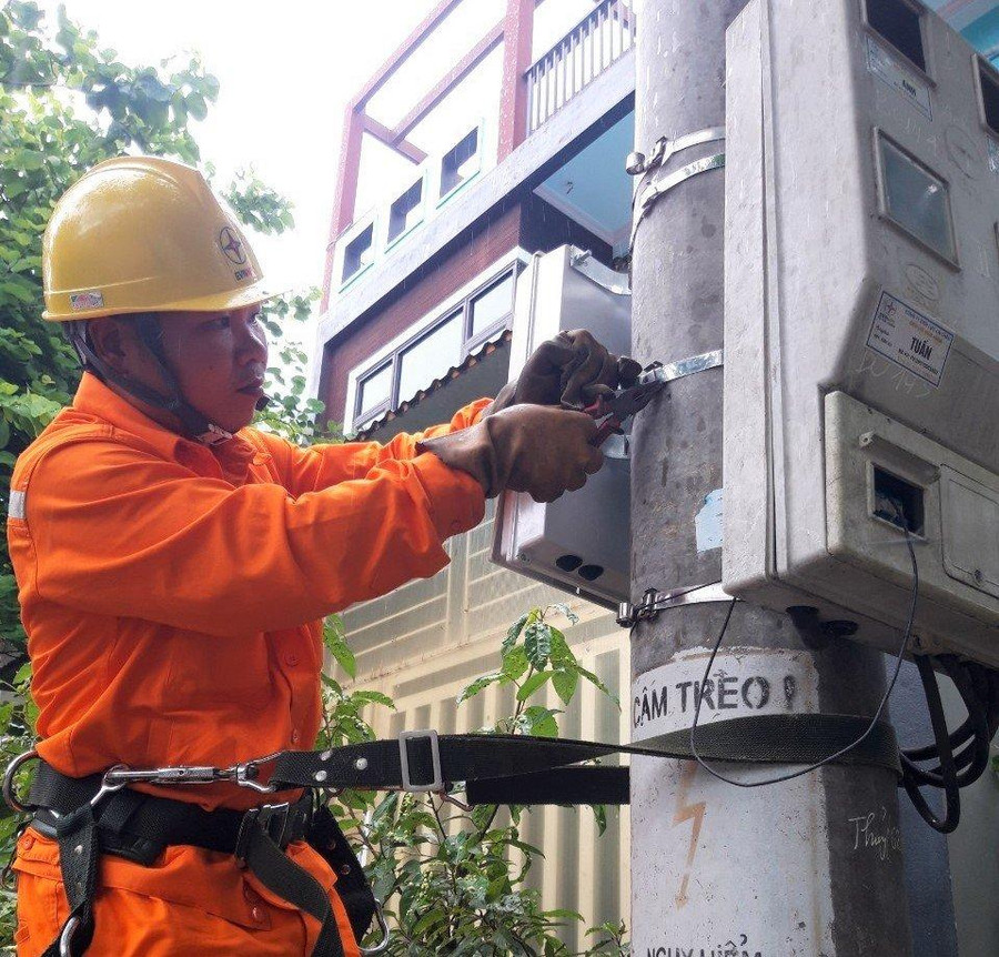 Công nhân Điện lực Than Uyên lắp đặt công tơ điện tử cho khách hàng.