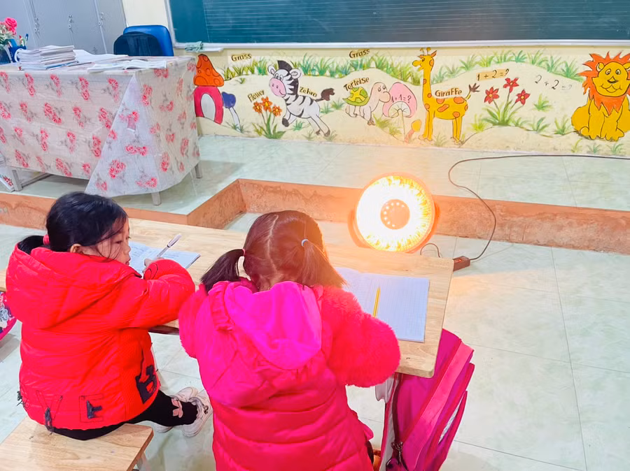 Học sinh trường Tiểu học Nậm Sài được sưởi ấm trong lớp học.