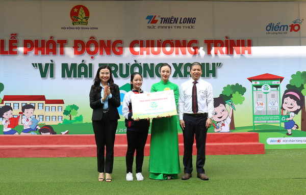 Chị Nguyễn Phạm Duy Trang - Phó Chủ tịch Thường trực Hội đồng Đội và đại diện Tập đoàn Thiên Long trao biểu trưng "Công trình măng non" cho thầy và trò trường tiểu học Phương Liệt.