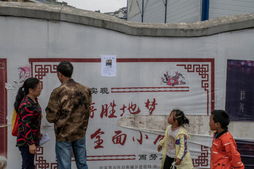 Hai vợ chồng ông Đường rong ruổi cả ngày để dán áp-phích và hỏi thăm về người con trai. Hai vợ chồng ông Đường rong ruổi cả ngày để dán áp-phích và hỏi thăm về người con trai. Ảnh: The New York Times.
