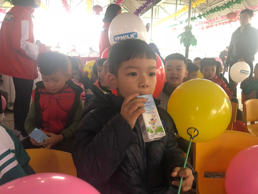 Các cháu nhỏ sử dụng sữa được phát tại buổi lễ.