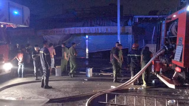 Lực lượng chức năng điều tra nguyên nhân cháy lúc nửa đêm. (Ảnh Khanh Đào)