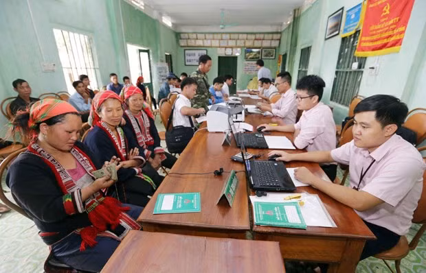 Đồng bào dân tộc thiểu số làm thủ tục vay vốn với cán bộ Ngân hàng Chính sách Xã hội. (Ảnh: CTV/Vietnam+) 