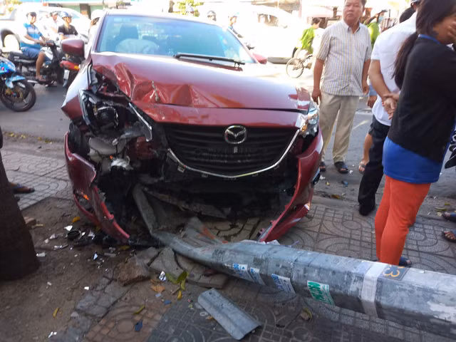  Trụ đèn giao thông đỡ đạn cho 3 người đàn ông đang ngồi trên vỉa hè. 