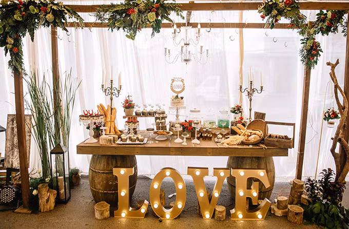 [Caption]các gam màu nâu, đỏ, xanh lá đậm từ không gian đến các loại hoa như artiso, sen đá và cả quả thông khô được bày trí cùng với những chất liệu gần gũi như gỗ, rơm, giúp không gian lễ cưới trở nên ấm cúng và thân thuộc hơn.