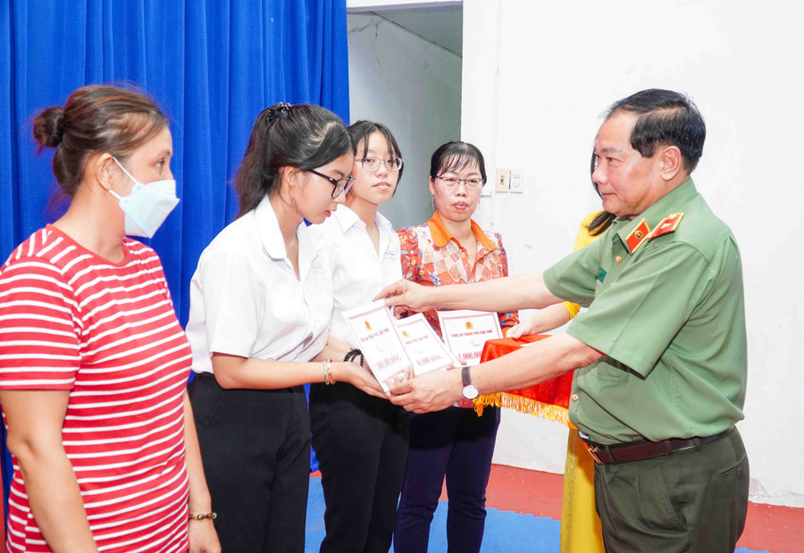 Ông Trần Thanh Bình (hình bên trái) và Thiếu tướng Nguyễn Văn Thuận trao quà cho HS.