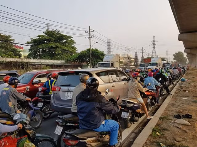 Do bị xe hơi, xe tải chèn lấn hết phần đường của mình, nhiều người đi xe máy bất lực nhìn sự hỗn loạn