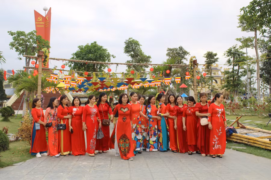 Hội chị em thướt tha trong tà áo dài đỏ thắm tranh thủ chụp ảnh lưu niệm nhân dịp vãn cảnh chùa Bụt. Ảnh: LT.