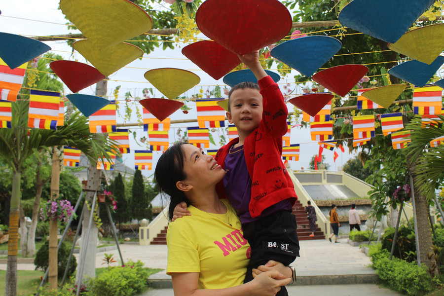 Lần đầu cùng con tới vãn cảnh chùa, chị Lê Thị Thắm (TP Thanh Hóa, người trong ảnh) vô cùng ấn tượng với kiến trúc độc đáo của ngôi chùa. "Không gian của ngôi chùa này rất thoáng mát, lại sát ngay cửa biển. Kiến trúc ngôi chùa cũng rất độc và lạ. Tôi dự định rủ thêm bạn bè tới tham quan và chụp ảnh lưu niệm", người phụ nữ này chia sẻ. Ảnh: LT. Lần đầu cùng con tới vãn cảnh chùa, chị Lê Thị Thắm (TP Thanh Hóa, người trong ảnh) vô cùng ấn tượng với kiến trúc độc đáo của ngôi chùa. "Không gian của ngôi chùa này rất thoáng mát, lại sát ngay cửa biển. Kiến trúc ngôi chùa cũng rất độc và lạ. Tôi dự định rủ thêm bạn bè tới tham quan và chụp ảnh lưu niệm", người phụ nữ này chia sẻ. Ảnh: LT.