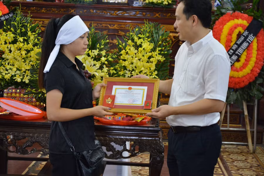 Ông Nguyễn Hoàng Phúc - Phó Giám đốc TT ĐPGTQG thừa lệnh Bộ trưởng Bộ Y tế trao tặng Kỷ niệm chương Vì sức khỏe nhân dân cho đại diện gia đình