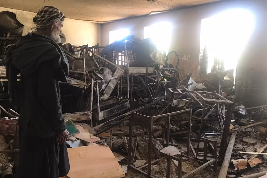 Bảo vệ trường nữ sinh Sher Ali Khan đang xem cảnh hoang tàn sau trận bom