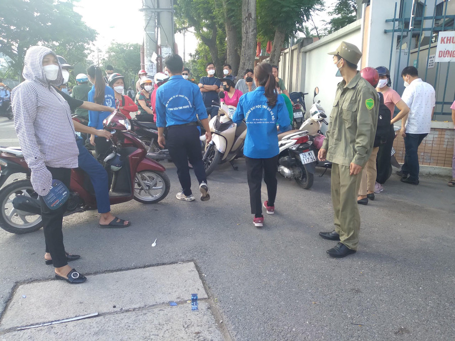 Các em phối hợp với trật tự phường đi nhắc nhở phụ huynh không cản trở giao thông ở khu vực cổng trường thi.