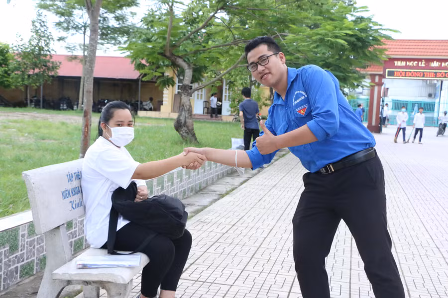 Cái bắt tay truyền cảm hứng của anh chị thanh niên tình nguyện gửi tới thí sinh trước khi vào phòng thi tại Trường THPT Mỹ Lộc.