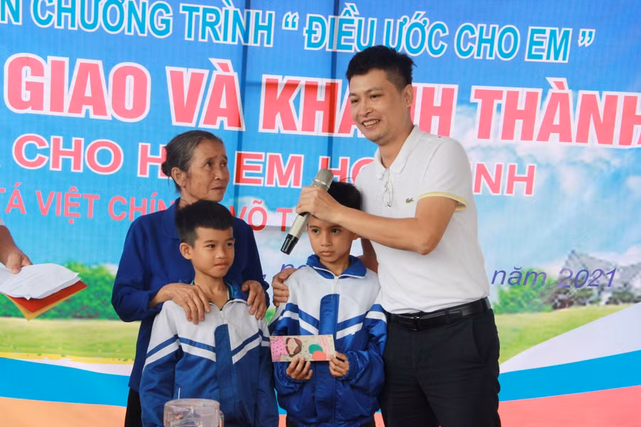 Đại diện Cty Truyền thông Giáo dục và Thời đại Ecom tặng quà cho 3 bà cháu, hỗ trợ thêm nguồn kinh phí nhỏ mua sắm dụng cụ sinh hoạt.