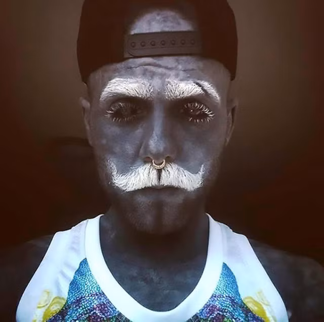 Adam đã xăm da thành màu xám và nhuộm lông mày, lông mi, râu thành màu trắng