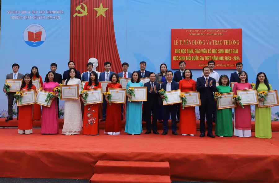 Phó Bí thư Thường trực Tỉnh ủy Lại Thế Nguyên và Chủ tịch UBND tỉnh Đỗ Minh Tuấn tặng hoa và Bằng khen của Chủ tịch UBND tỉnh cho giáo viên có học sinh đoạt giải Quốc gia.