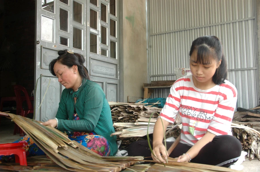 Trong những ngày chờ nhập học, Nghi phụ mẹ chằm lá kiếm tiền trang trải cuộc sống. 