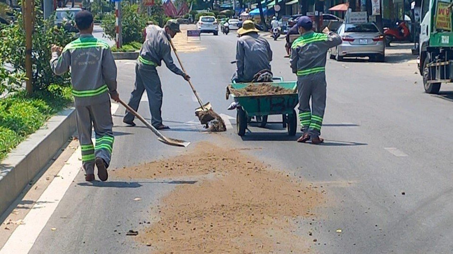 Nhân viên công ty môi trường rải cát xử lý vết dầu nhớt phủ trên nền đường. Nhân viên công ty môi trường rải cát xử lý vết dầu nhớt phủ trên nền đường.