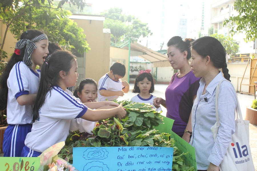 Phụ huynh đồng hành cùng các con trong phiên chợ rau do trường tổ chức 