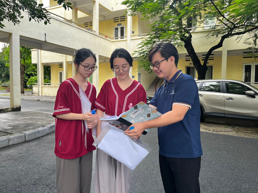 Thí sinh tranh thủ trao đổi bài trước khi vào phòng thi.