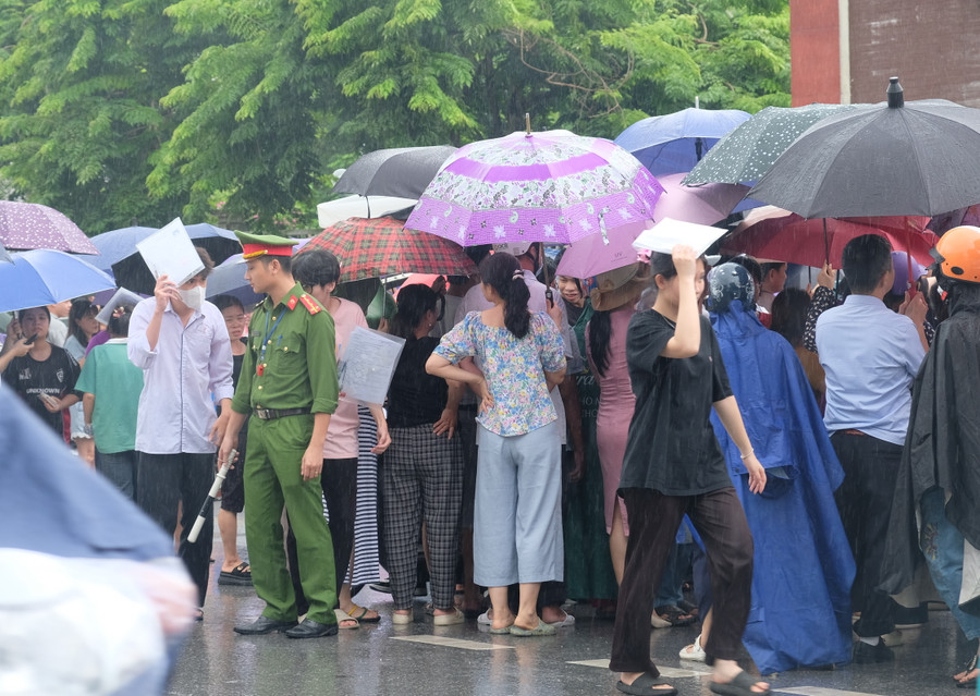 Thời điểm thí sinh rời khỏi phòng thi, trời đổ mưa khiến lực lượng chức năng làm nhiệm vụ cũng như thí sinh ra về gặp nhiều khó khăn.