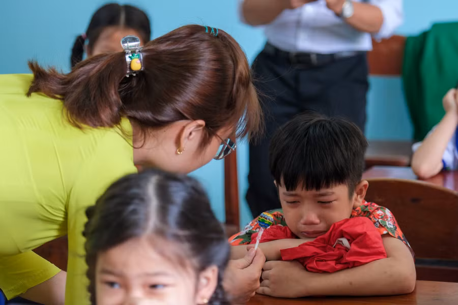 Học sinh khóc mè được cô dỗ dành trong ngày tựu trường.