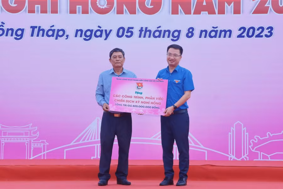 Đồng chí Nguyễn Tường Lâm trao bảng tượng trưng các công trình, phần việc cho đại diện xã Tân Kiều.