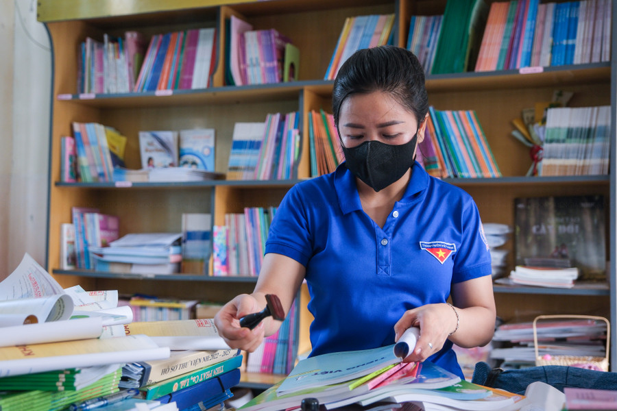 Giáo viên sắp xếp lại thư viện trường học. Giáo viên sắp xếp lại thư viện trường học.