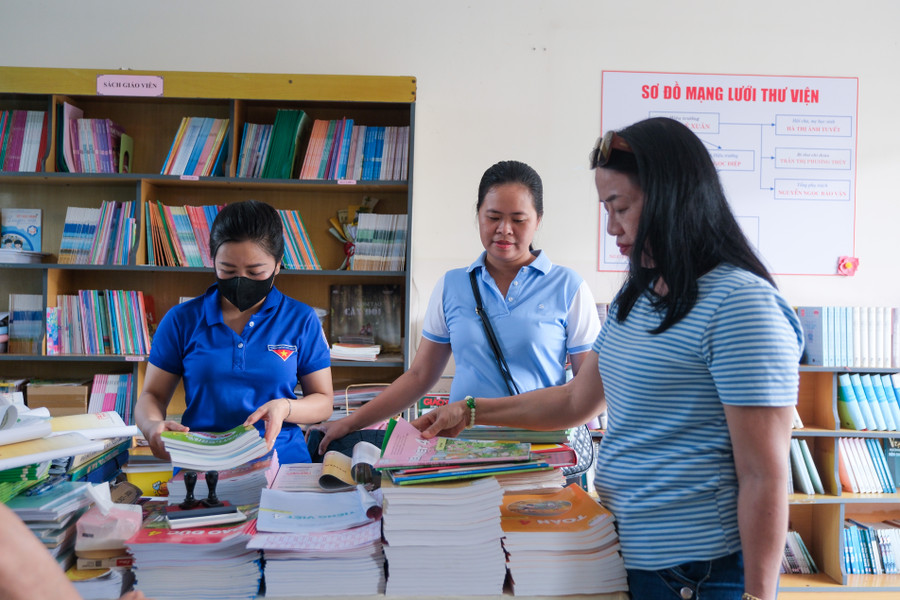 Giáo viên sắp xếp lại thư viện trường học. Giáo viên sắp xếp lại thư viện trường học.