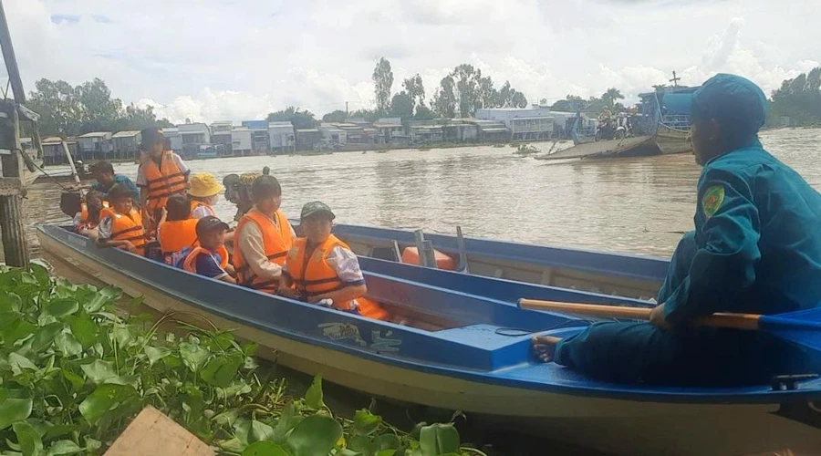 Cùng với thầy cô giáo, các lực lượng quân sự, dân quân tự vệ dùng vỏ lãi đưa rước học sinh tại các xã vùng đầu nguồn.