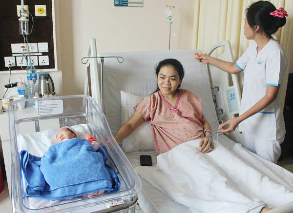 Bé trai khỏe mạnh bên cạnh mẹ sau ca mổ kép. Bé trai khoẻ mạnh bên cạnh mẹ sau cuộc mổ. Ảnh: M.T